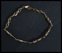A hallmarked 9ct gold bracelet being set with whit