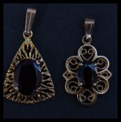 Two 9ct gold and garnet pendants. Unmarked, tests