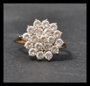 A 9ct gold and white stone cluster ring. Remnants