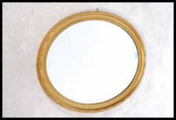A 1930's gilt wood oval wall mirror. The shaped gi
