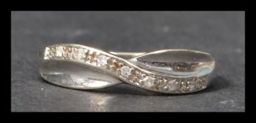 A hallmarked white gold and diamond crossover band