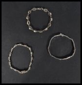 A group of three sterling silver tennis bracelets