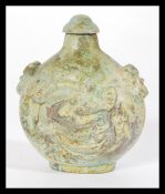 A Chinese soap stone snuff bottle of bulbous form with dragon decoration and fu dog handles.