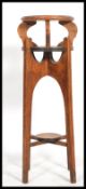 A 1920's oak torcere - plant stand being raised on sabre supports with circular twin tiers atop