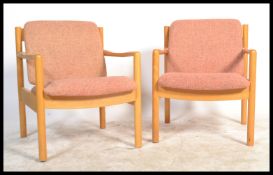 A pair of 20th century Ercol staff chairs. Light beech wood turned construction with shaped elbow