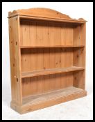 An antique style large open window country pine bookcase cabinet having a plinth base with a