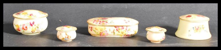 A group of five Royal Worcester ivory blush lidded trinket pots having hand painted floral