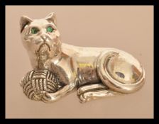 A sterling silver figurine of a cat playing with a ball of wool. Weighs 19 grams.