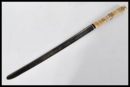 An early 20th century Chinese short sword having a carved bone handle. The blade made of a cut
