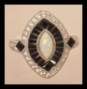 A sterling silver CZ and paneled sapphire dress ring with central lozenge shaped opal. Size P.5