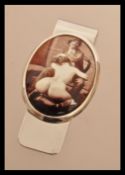 A sterling silver money clip having an erotic enamel panel scene. Weighs 20 grams.