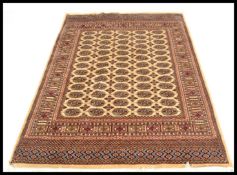 An early 20th century Persian handwoven Bokhara rug having central multiple medallions raised on