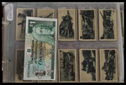 An album containing a collection of vintage cigarette cards dating from the early 20th century to