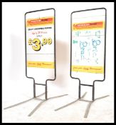 A pair of retro 20th century shop point of sale advertising billboards, swing board set within a