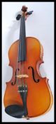A vintage 20th century student violin with pierced hollow body and shaped neck and head. Makers