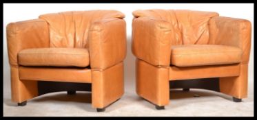 A pair of 20th century Italian tan brown leather club armchairs. Each of tub form with upholstered