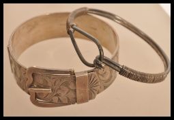 Two silver hallmarked bangles one of belt and buckle form with chased decoration along with