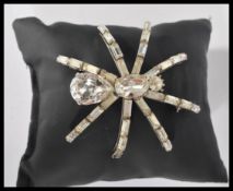 A large retro 20th century emerald cut white stone brooch in the form of a spider.
