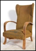 A retro mid century bentwood armchair being raised on splayed legs with wingback rest and shaped
