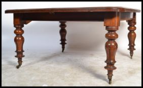 A 19th Century Victorian mahogany large square wind out dining table, raised on fluted and turned