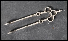 An early 20th century silver hallmarked pair of sugar tongs nips by Thomas Bradbury & Sons Ltd