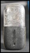 An early 20th century silver plated hunting interest leather and glass hip flask having scrolled