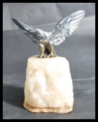 An early 20th century silver plated figurine of an eagle bird with wings spread raised on a rock