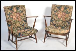 A pair of 1970's beech and elm Windsor pattern armchairs of low form with chintz pad cushions and