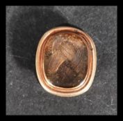 A 9ct gold mourning collar stud button with inset woven lock of hair. Weighs 2.5 grams.