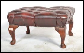 An antique style Chesterfield footstool having button backed oxblood leather top raised on