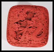 An early 20th century Chinese cinnabar lacquer trinket makeup box depicting dragons and trees.