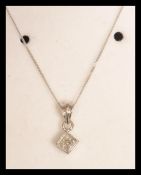 A 9ct white gold pave set diamond necklace pendant on gold chain. Complete in presentation box.
