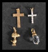 A collection of four 9ct gold necklace pendants to include Snoopy, crucifix and briolette crystal