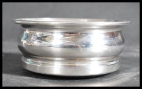 A silver hallmarked wine bottle coaster, London assay marks,makers marks for C J Vander Ltd and