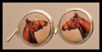 A pair of sterling silver cuff links having enamel panels depicting horses. Weighs 11 grams.