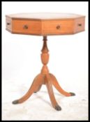 A reproduction antique style octagonal pedestal drum table raised on a turned column with splayed