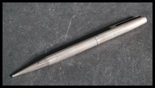 A silver hallmarked propelling pencil of larger form with engine turned decoration. Weighs 29.0