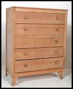 A 20th century Art Deco style oak chest of drawers being raised on kick legs with a bank of 6