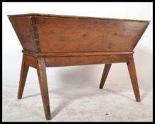 A stunning 19th Century elm dough bin of angular form, panel top raised on a splayed frame.