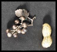 An unusual enamel pill pot box in the form of a peanut along with a silver white metal grapes and