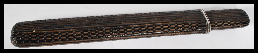 An early 20th century silver and bronze mounted pen case of elongated form having detailed applied