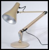 A vintage 20th century Herbert Terry anglepoise desk lamp being raised on circular terraced base