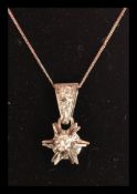 An 18ct white gold necklace pendant in the form of a star on 18ct gold chain. Complete in
