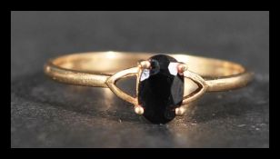 A 9ct gold and sapphire ring set with a single oval cut sapphire . Marked 9ct tests 9ct gold.