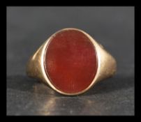 A hallmarked 9ct gold ring set with a carnelian flat cabochon. Hallmarked London. Weight 4.8g.