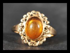 A hallmarked 9ct gold and amber cabochon ring. Hallmarked Sheffield. Weight 2.4g. Size O.
