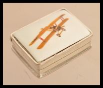 A sterling silver pill box having an enamel plaque of a bi plane to lid. Weighs 28 grams.