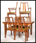 A retro 20th Century teak wood dining suite by Nathan, consisting of four dining chairs raised on