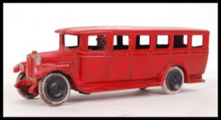 SKOGLUND AND OLSON RED PAINTED CAST IRON BUS WITH DRIVER