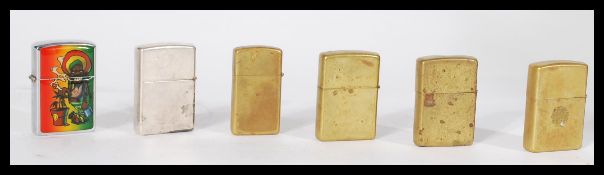 A group of five vintage Zippo lighters to include a VIII E07 1932-1987 etc. Along with another.